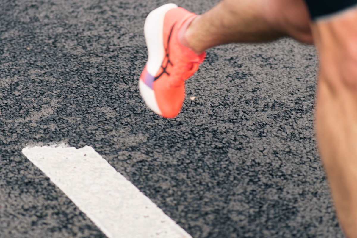 A runner's foot crossing a white line on the road
